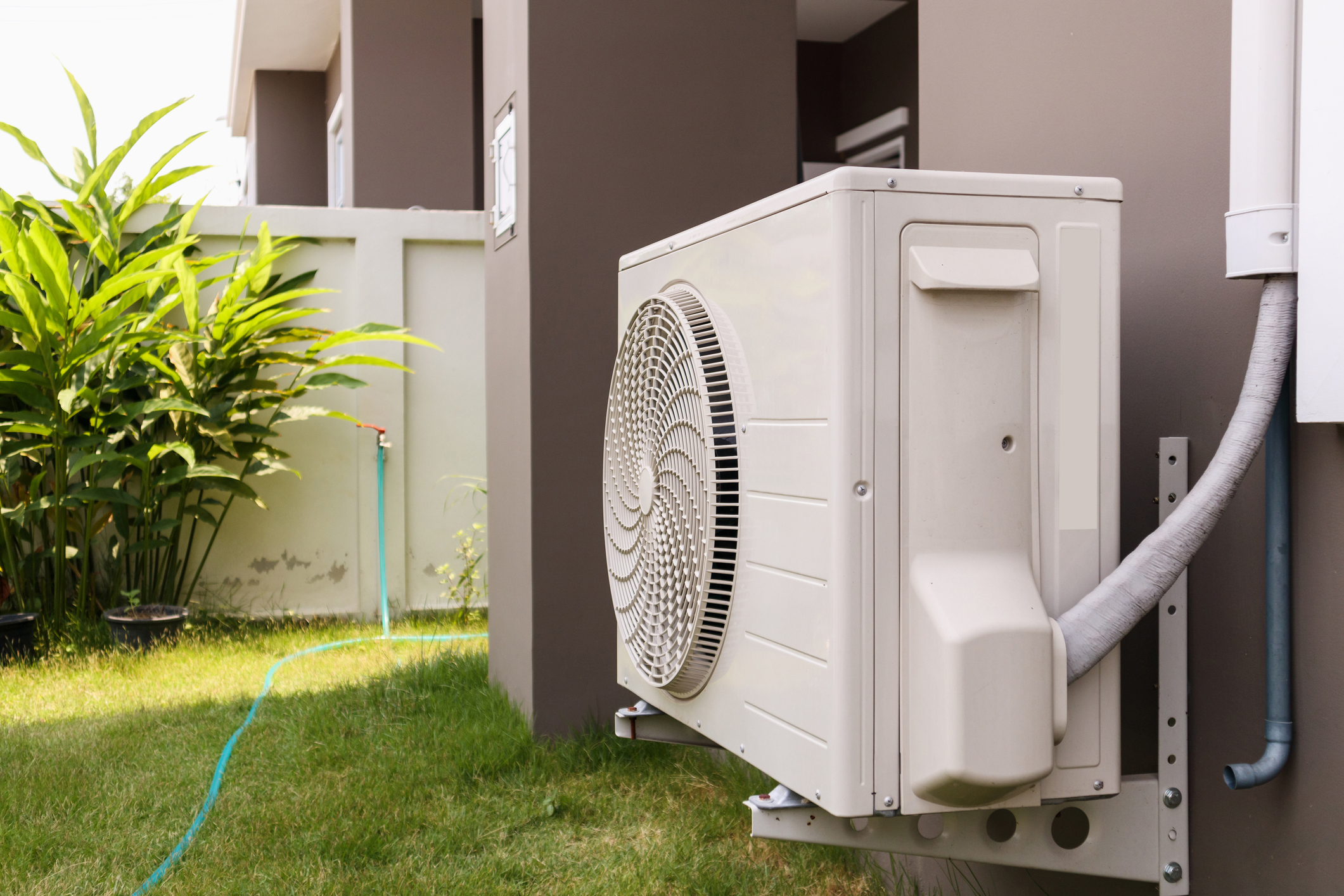 White air conditioner installed on outside of house